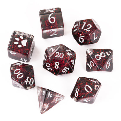 A 8-piece polyhedral dice set with a translucent dark red and black glitter finish, featuring silver printed numbers and thematic symbols like a paw print on a d6. The set is displayed on a clean white background.