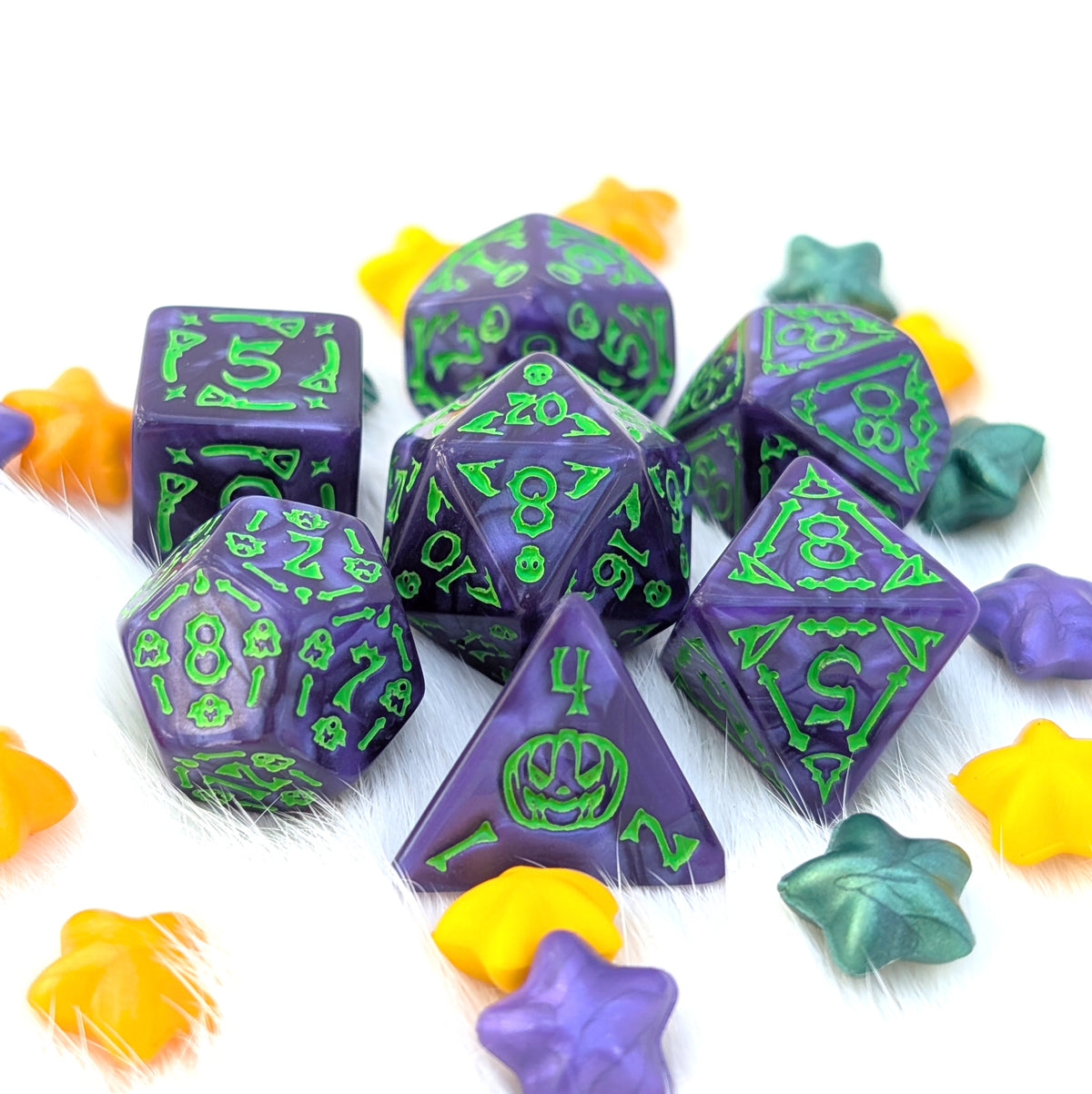 Moonlit Mischief purple Halloween acrylic DnD dice with pearly marbling, bright green numbers, and illustrations of ghosts, bats, broomsticks, skulls, bones, and jack-o'-lanterns