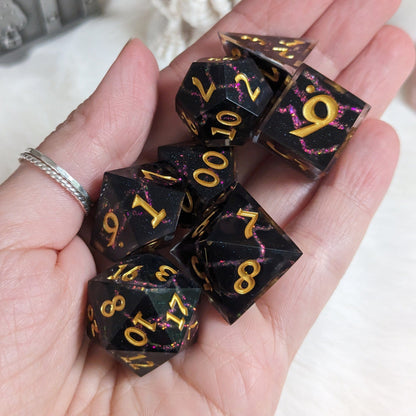 Hand holding Red Lightning DnD dice set, featuring black resin with glittering red lightning design and sharp edges for TTRPG gaming.