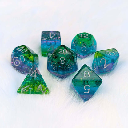 Aurora Sparkle Dice Set with green, blue, and purple hues and glitter on a white background, perfect for tabletop games.