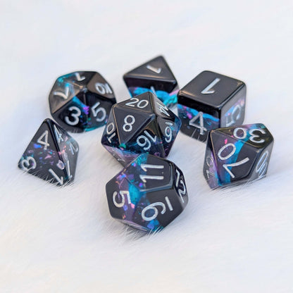 Midnight Nebula round-edge dice set with black, blue, and purple layers featuring glitter flakes on a soft white background.