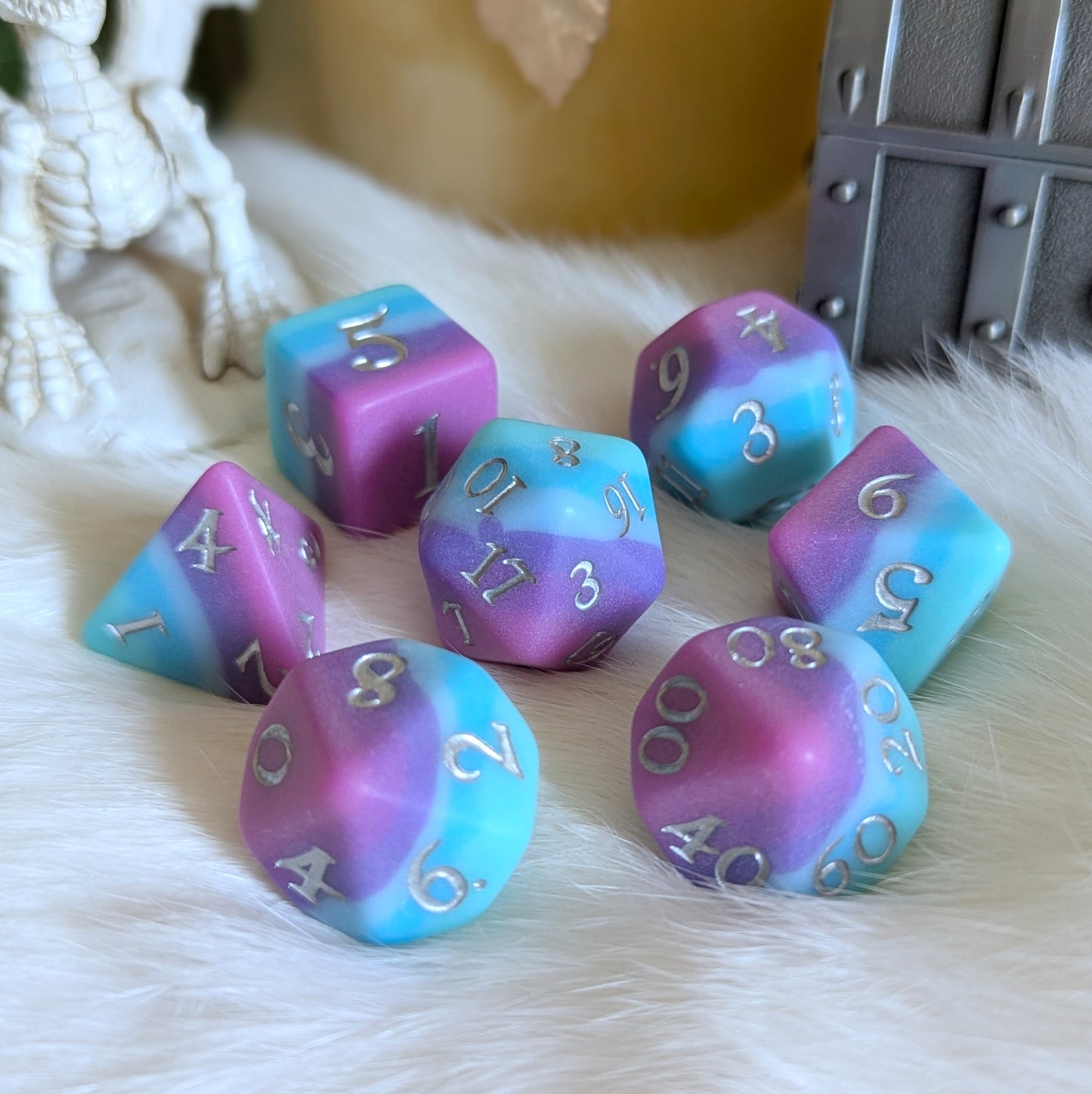 Twilight Serenity Dice Set with ombre colors of teal, blue, purple, and pink displayed on a soft surface.