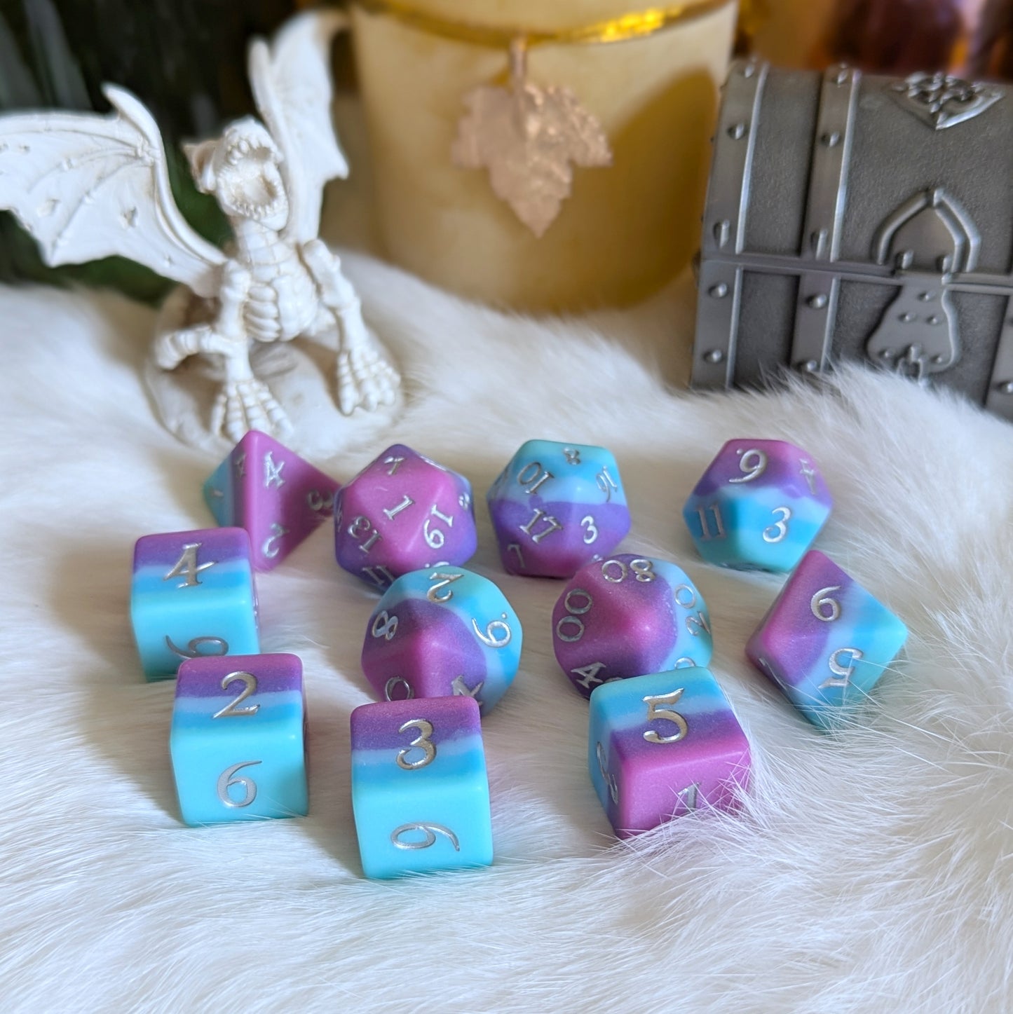 Twilight Serenity Dice Set featuring ombre teal to pink hues, perfect for TTRPG gameplay, displayed on a fluffy surface with decor.