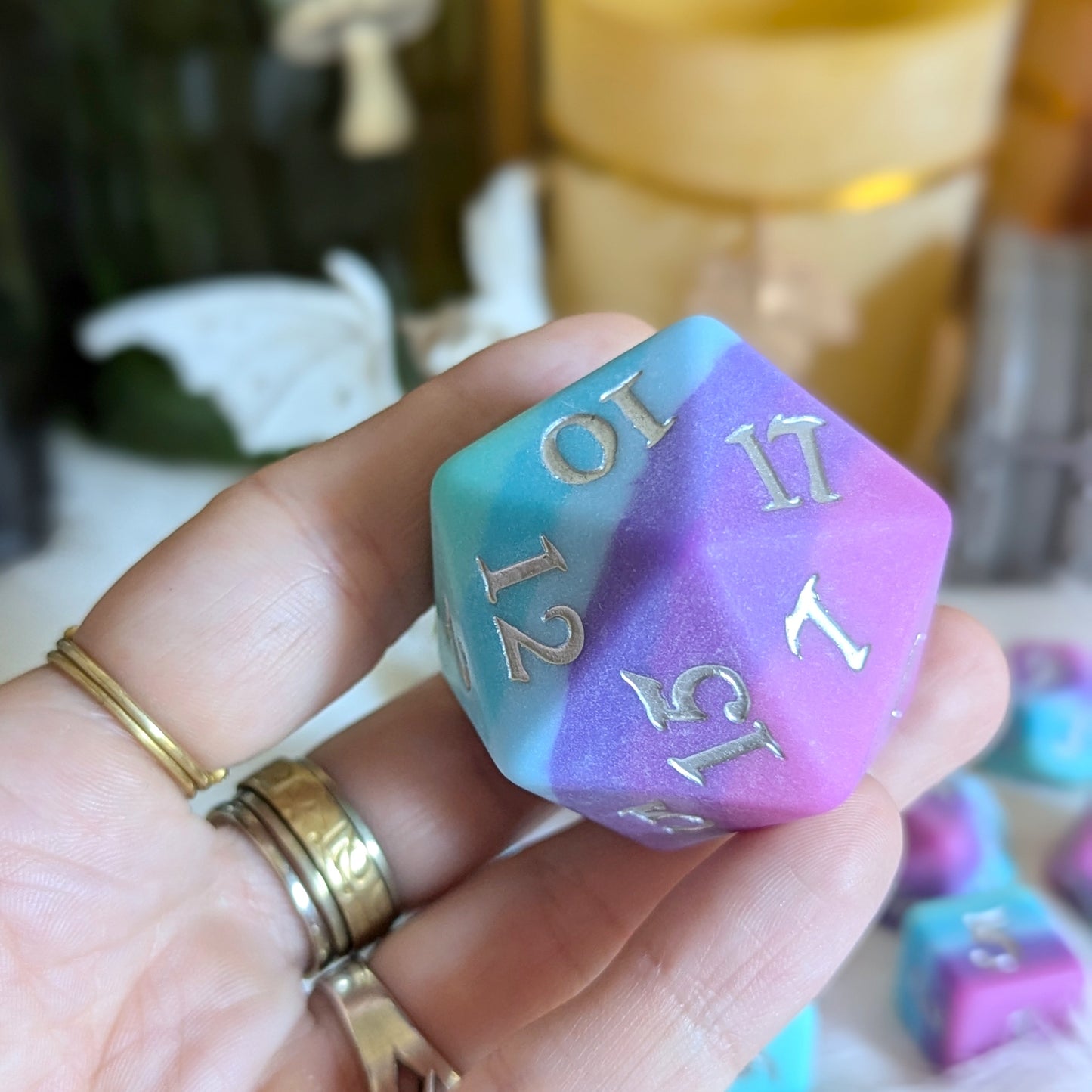 Twilight Serenity Dice featuring ombre colors from teal to purple, held in hand, perfect for TTRPG enthusiasts.