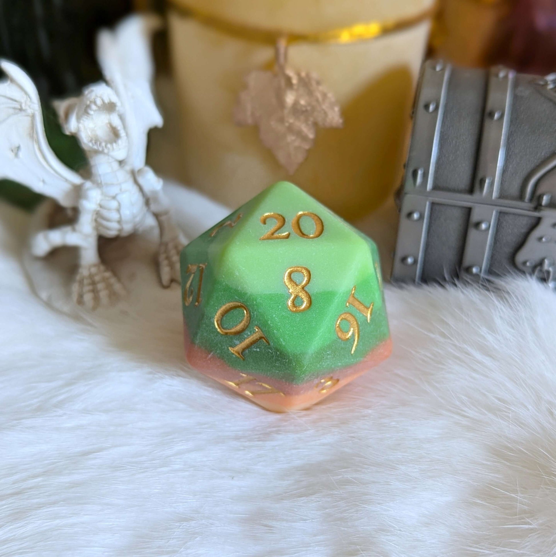 Forest's Heart Large D20 with gold fantasy numbers, in green to brown gradient, on a soft surface near fantasy decor.