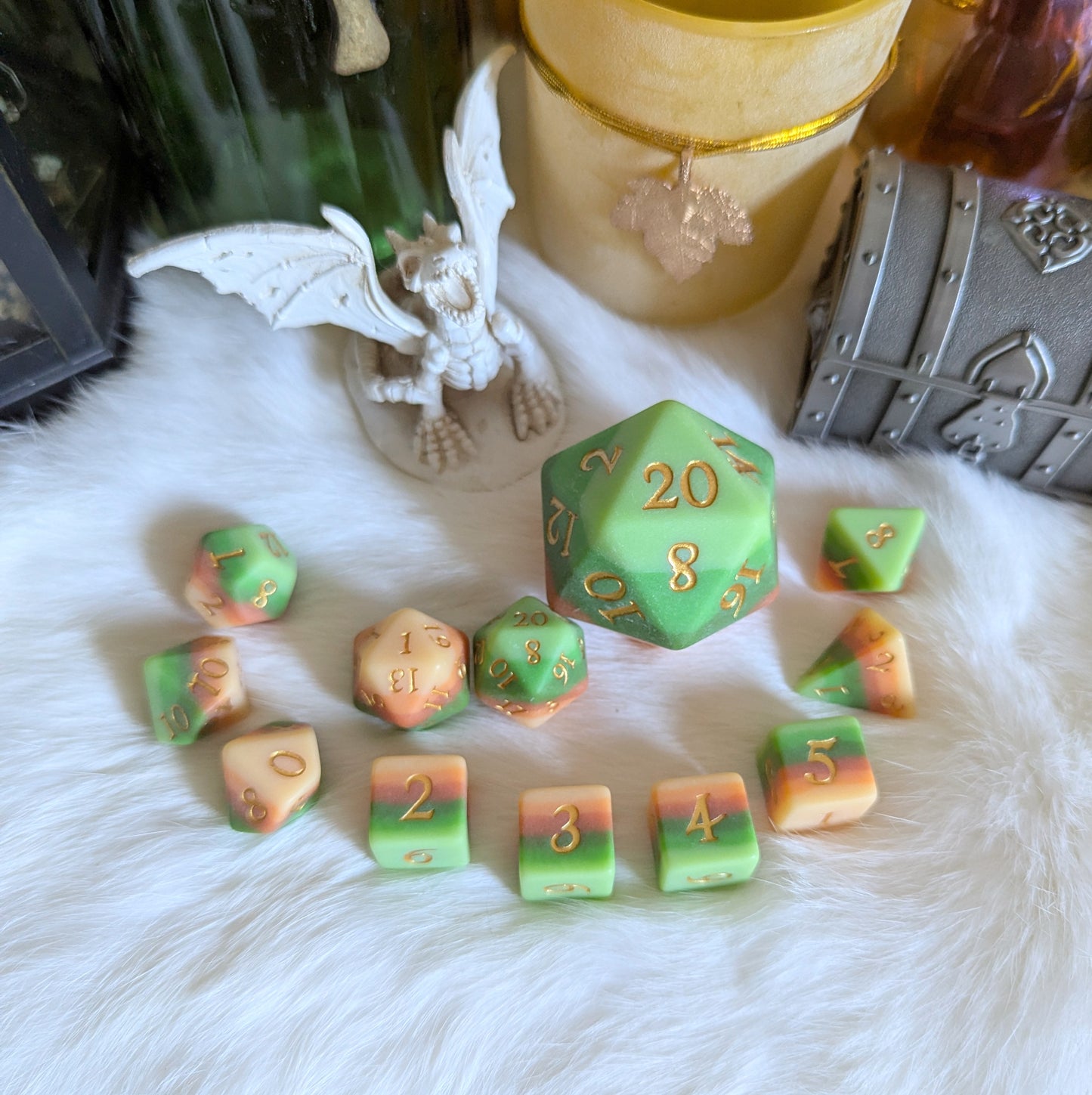 Forest's Heart dice set with ombre green to brown resin and metallic gold numbers displayed on soft white fur.