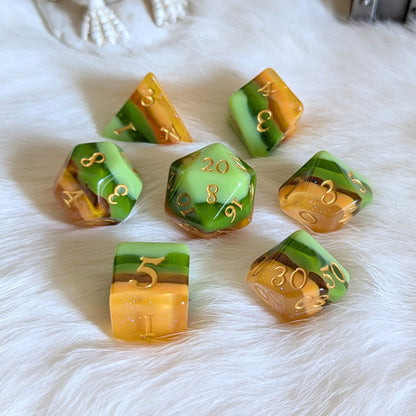 Timberlight Dice Set with ombre green and brown hues, featuring metallic gold numbers, displayed on a soft white surface.