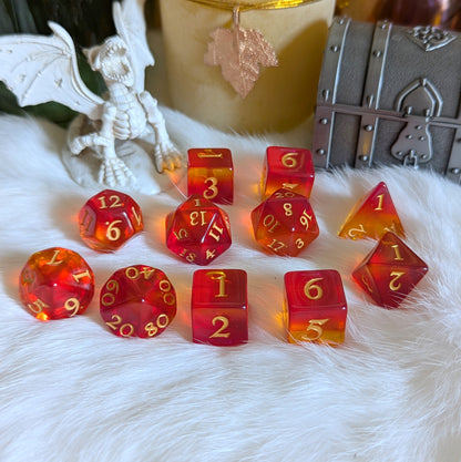 Dragon Fire Dice Set with ombre red and orange design, featuring a dragon figurine in the background and a treasure chest.