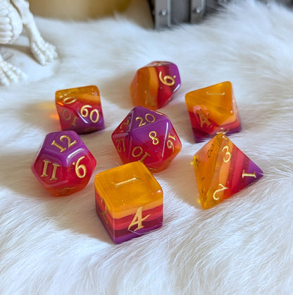 Emberstorm Dice Set with vibrant layers in purple, red, and orange, showcasing glittery shimmer on a soft, white surface.