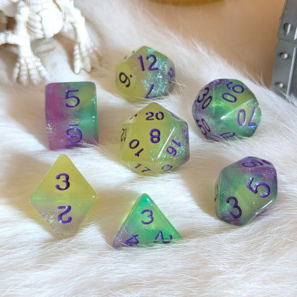 Dreamlight Grove dice set with green-yellow, teal, and purple swirls, glowing on a soft white surface.