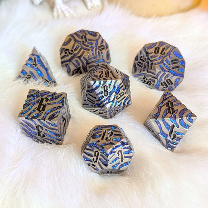 Silverfang metal dice set with blue glitter claw designs, displayed on a white surface.