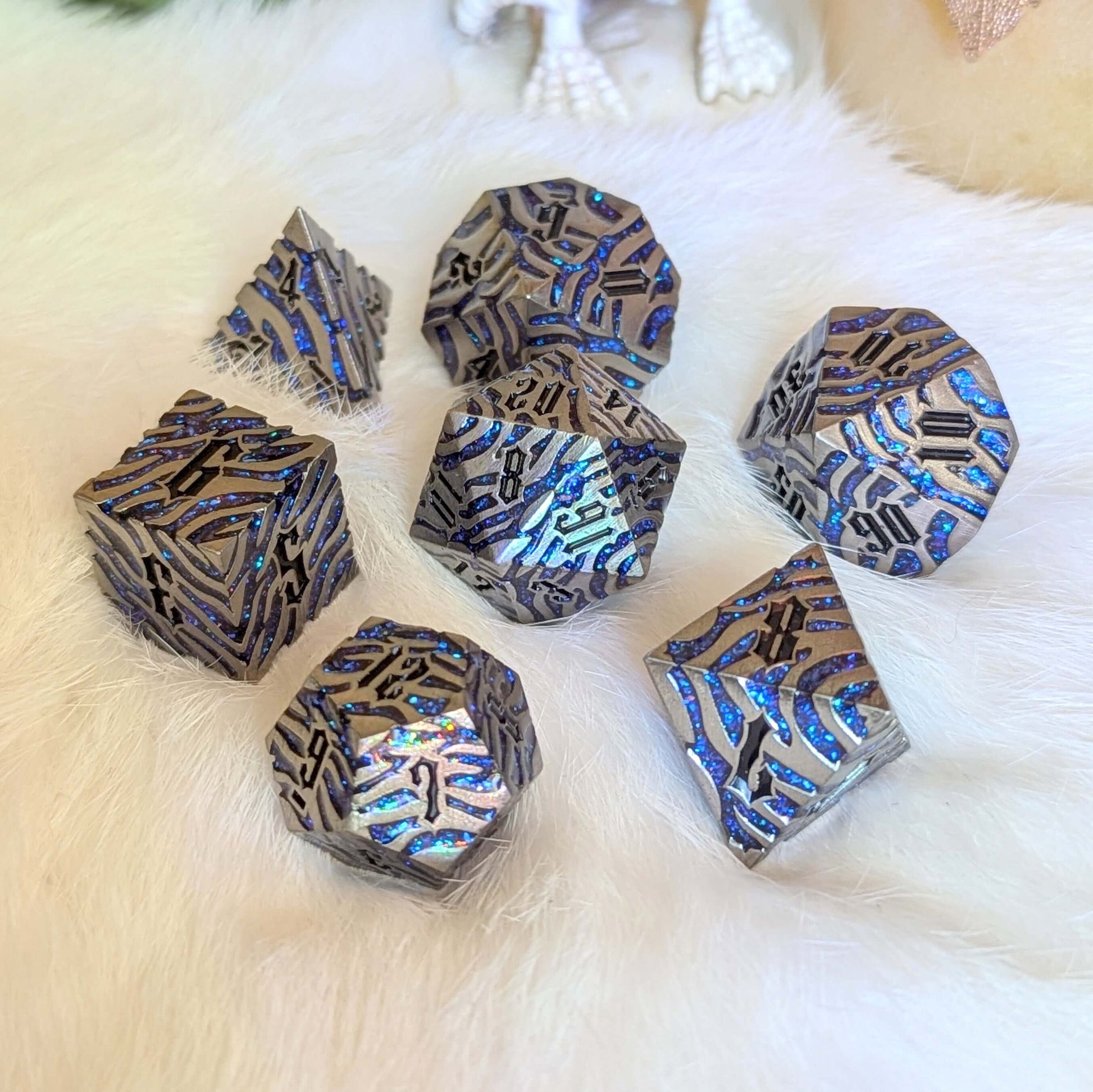 Silverfang Metal Dice Set with blue glitter and claw scratch designs displayed on soft white surface.