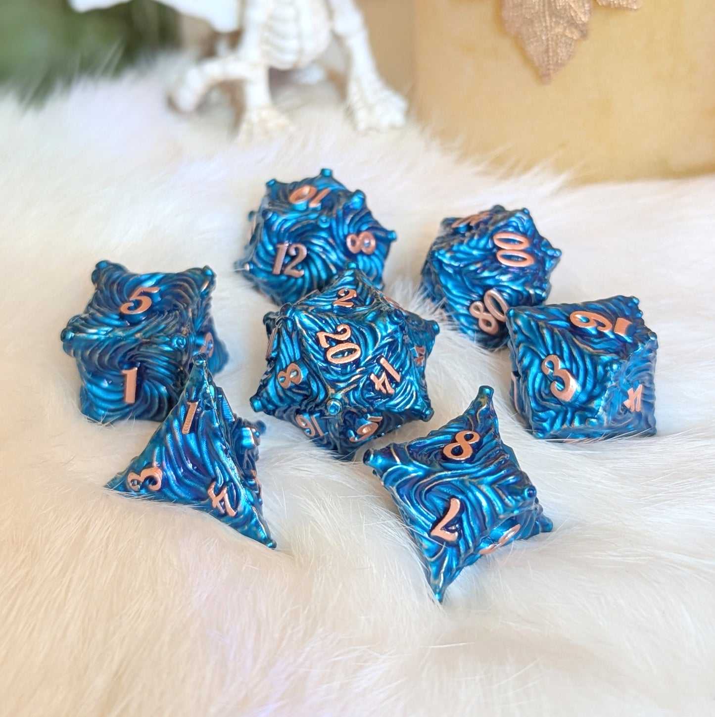 Blue Enchanted Bark Metal Dice Set with copper numbers on white fur background