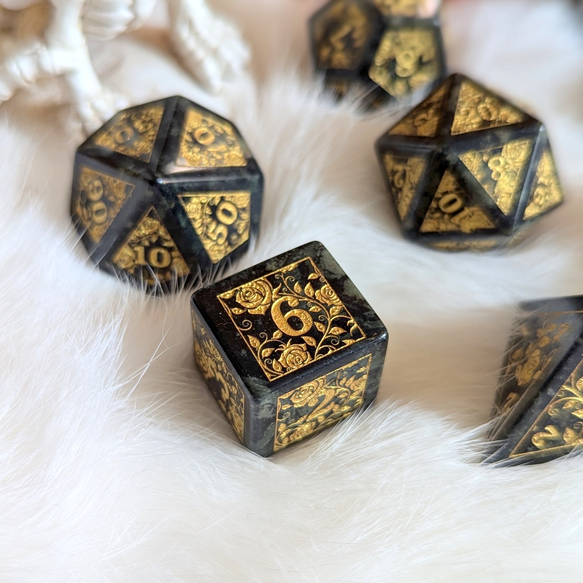 Kambaba Jasper Rose Dice Set with gold engraved rose designs on white fur background