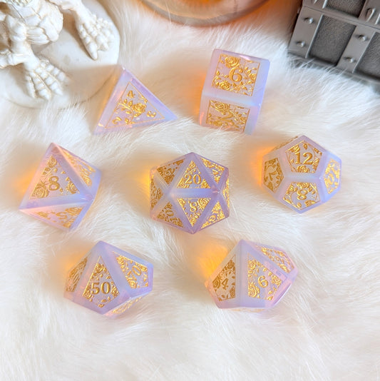 Pink Opalite Rose Vine Gemstone Dice Set on white fur, showcasing ethereal glow and gold rose engravings, adding elegance to tabletop games.