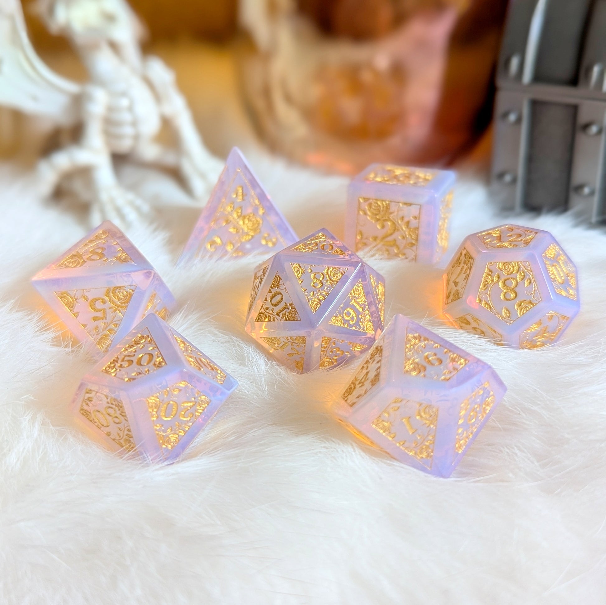 Pink Opalite Rose Vine Gemstone Dice Set with gold engravings on a soft white background, glowing ethereally in the light.