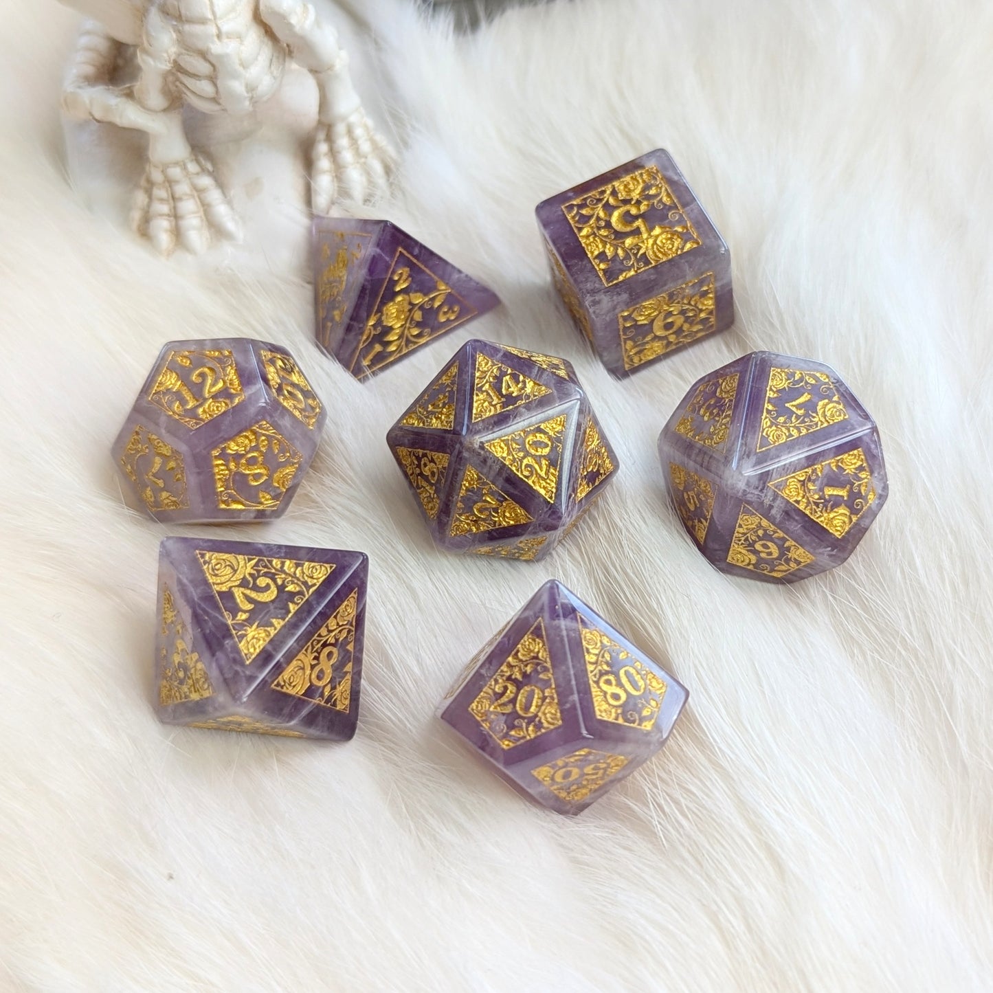 Amethyst Rose Vine Gemstone Dice Set with gold engravings on a soft white background.