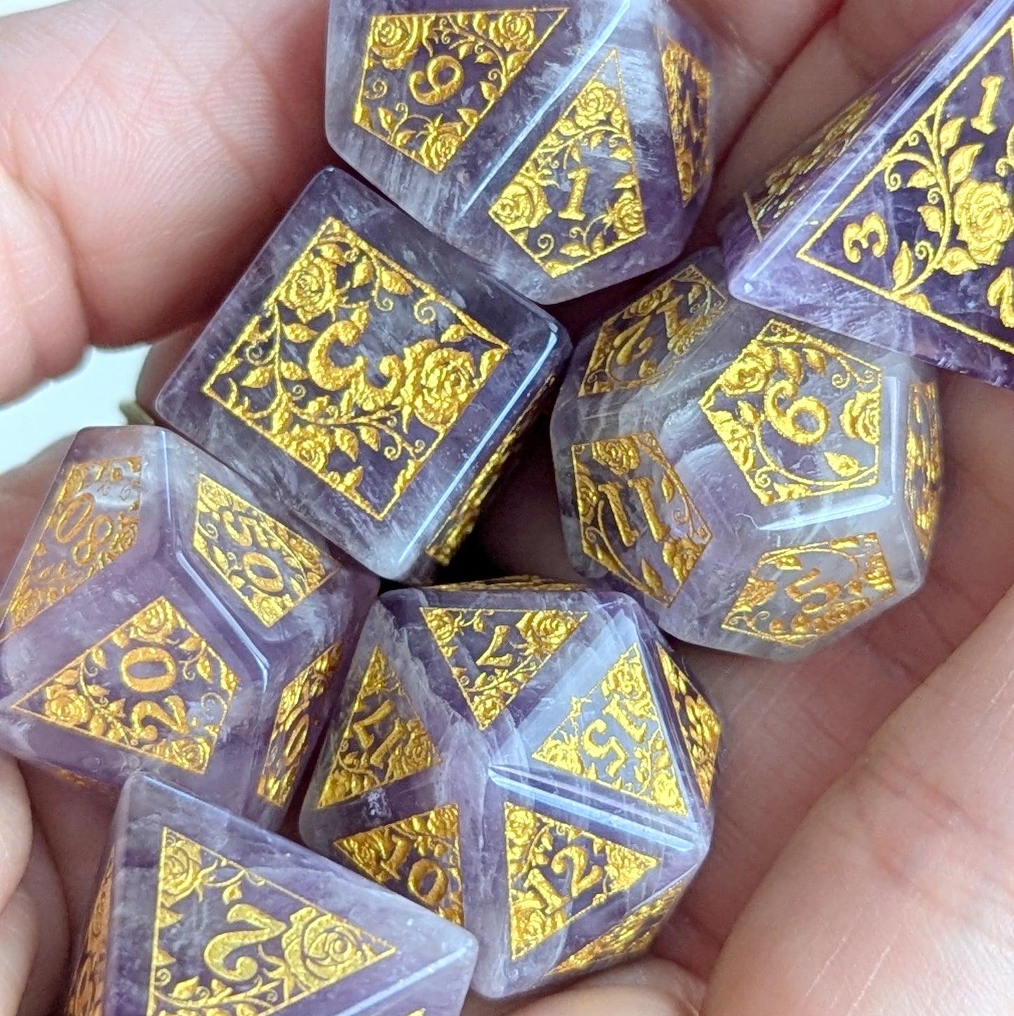 Amethyst Rose Vine Gemstone Dice Set with gold engraved rose designs held in hands