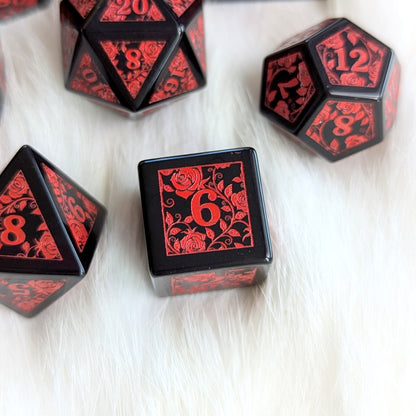 Obsidian Rose Vine Gemstone Dice Set with red floral engravings on smooth black obsidian, featuring numbers on a white background.