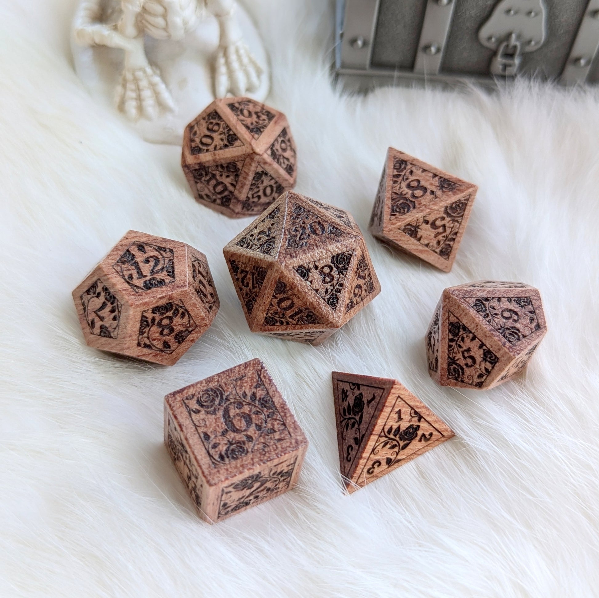 Rosewood Rose Vine Engraved Dice Set on white fur, featuring intricate rose vine designs on each die.