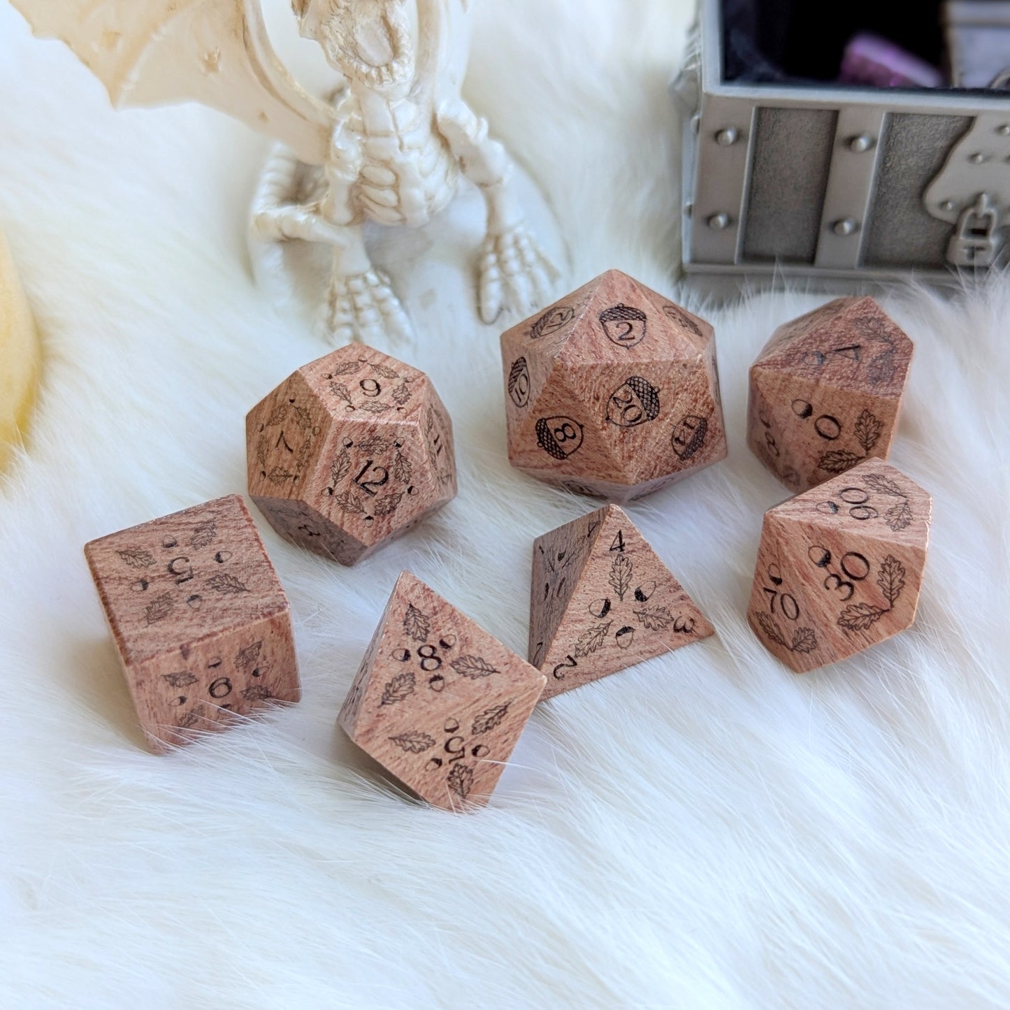 Oak Grove Engraved Rosewood Dice Set with acorn and oak leaf carvings on a plush white surface.