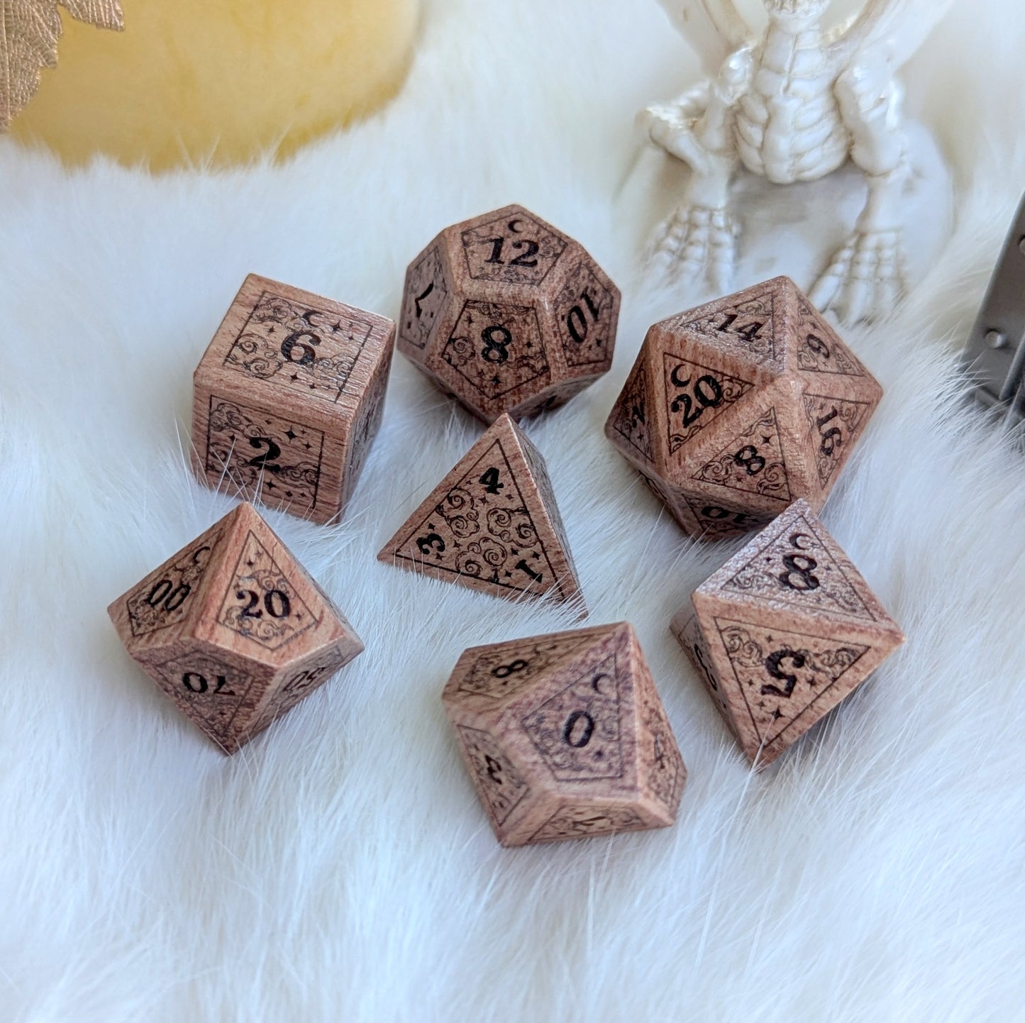 Dreamy Rosewood Engraved Dice Set with stars and crescent moon designs on a fluffy background.