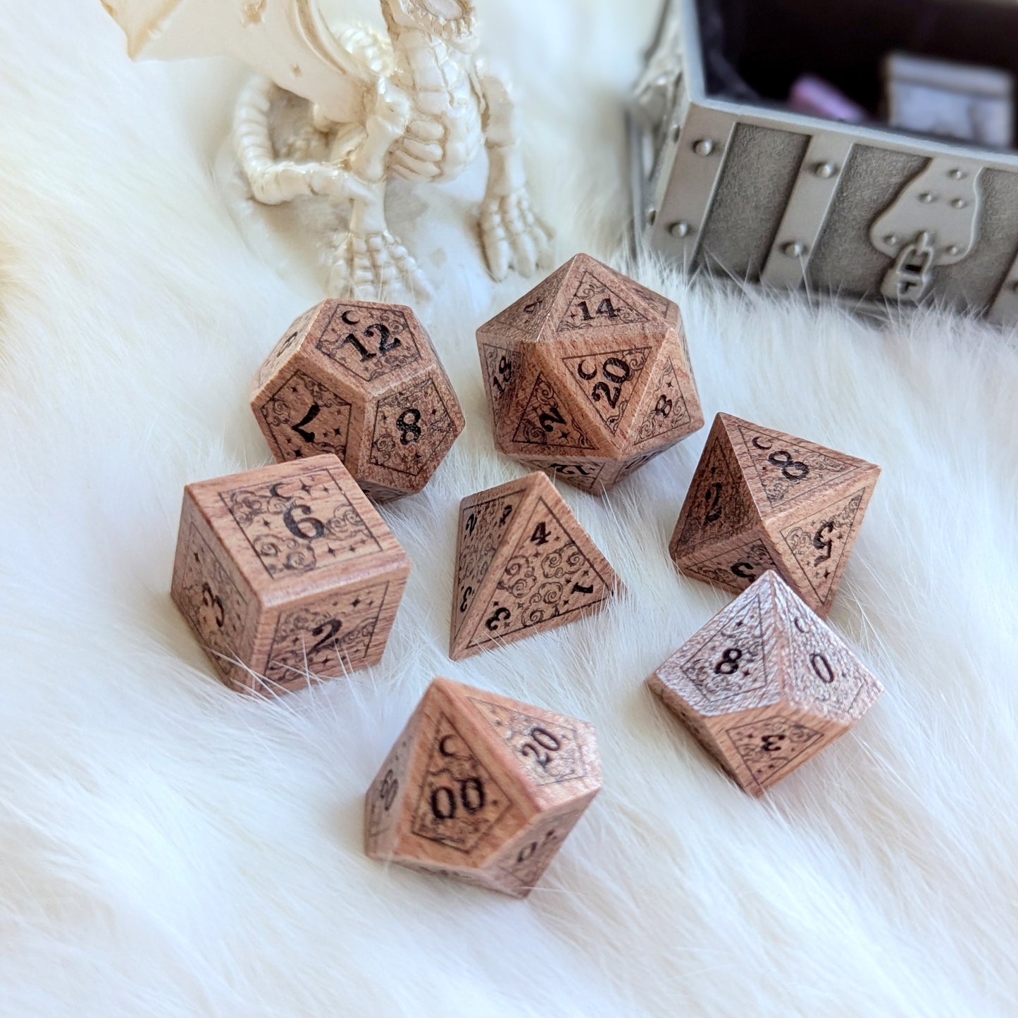 Dreamy Rosewood Engraved Dice Set on white fur, featuring intricately carved stars, clouds, and moon, with a dragon ornament nearby.