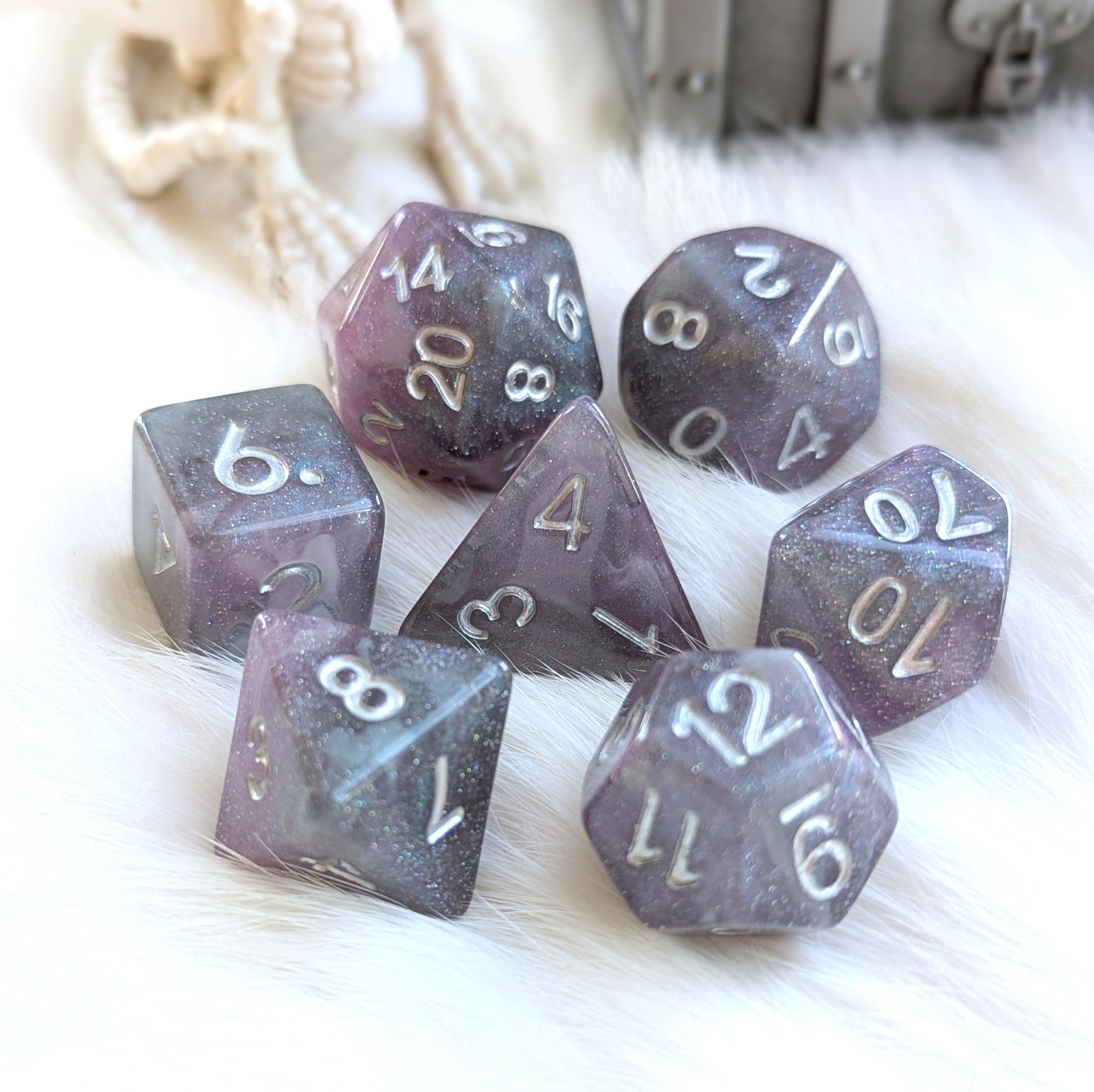 Shadow Veil Dice Set with shimmering grey, purple hues, and silver numbers on white fur, round-edge resin gaming dice.