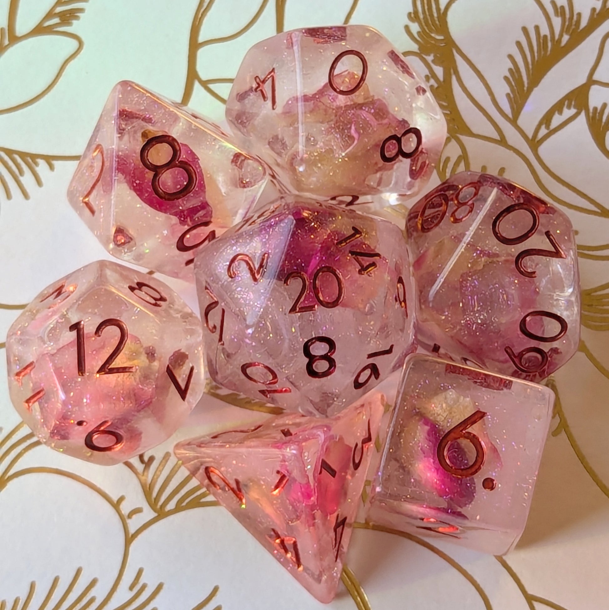 Eternal Rose Dice Set featuring pink rose petals in resin with metallic red numbers, perfect for tabletop gaming.