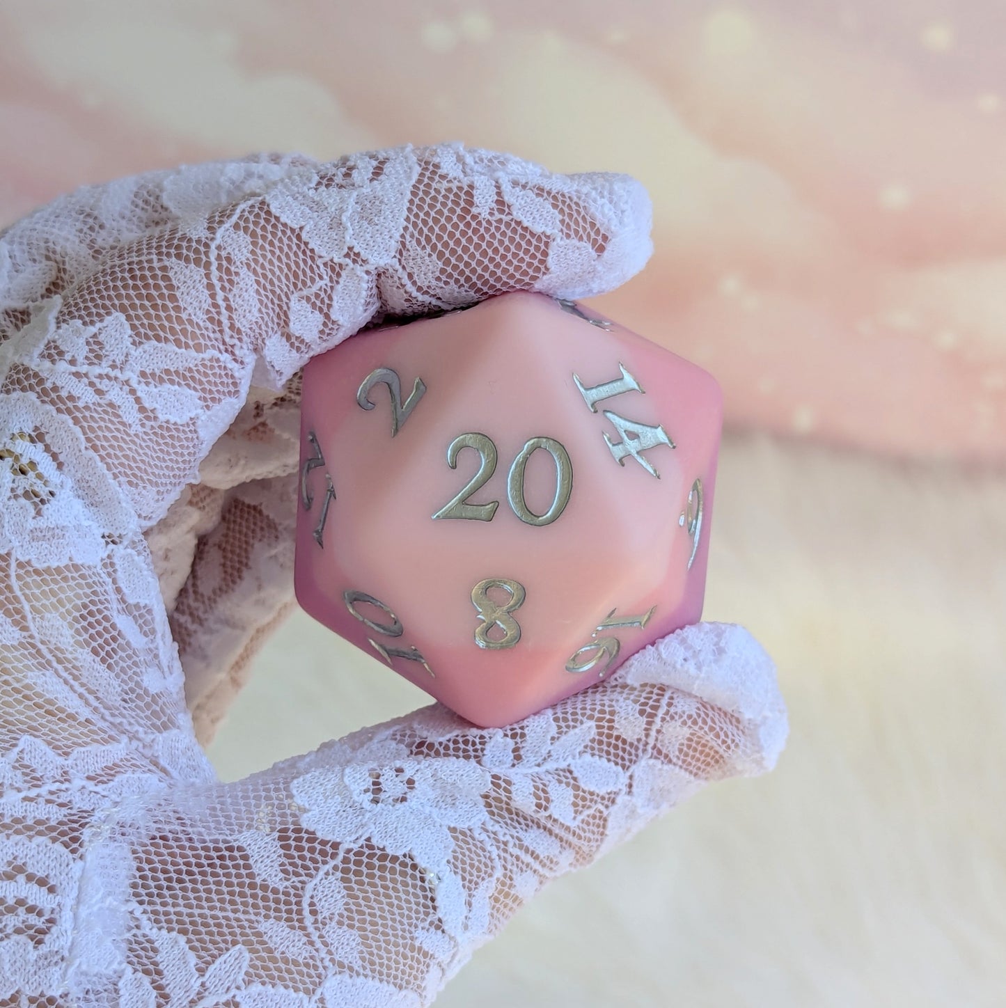 Dreamweaver Large D20 held in lace-gloved hand, featuring a matte ombre design in pink and lavender hues.