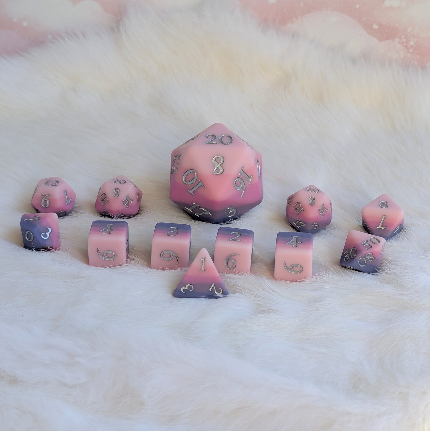 Dreamweaver D20 dice set featuring matte ombre design in pink and lavender hues on a soft fur background.