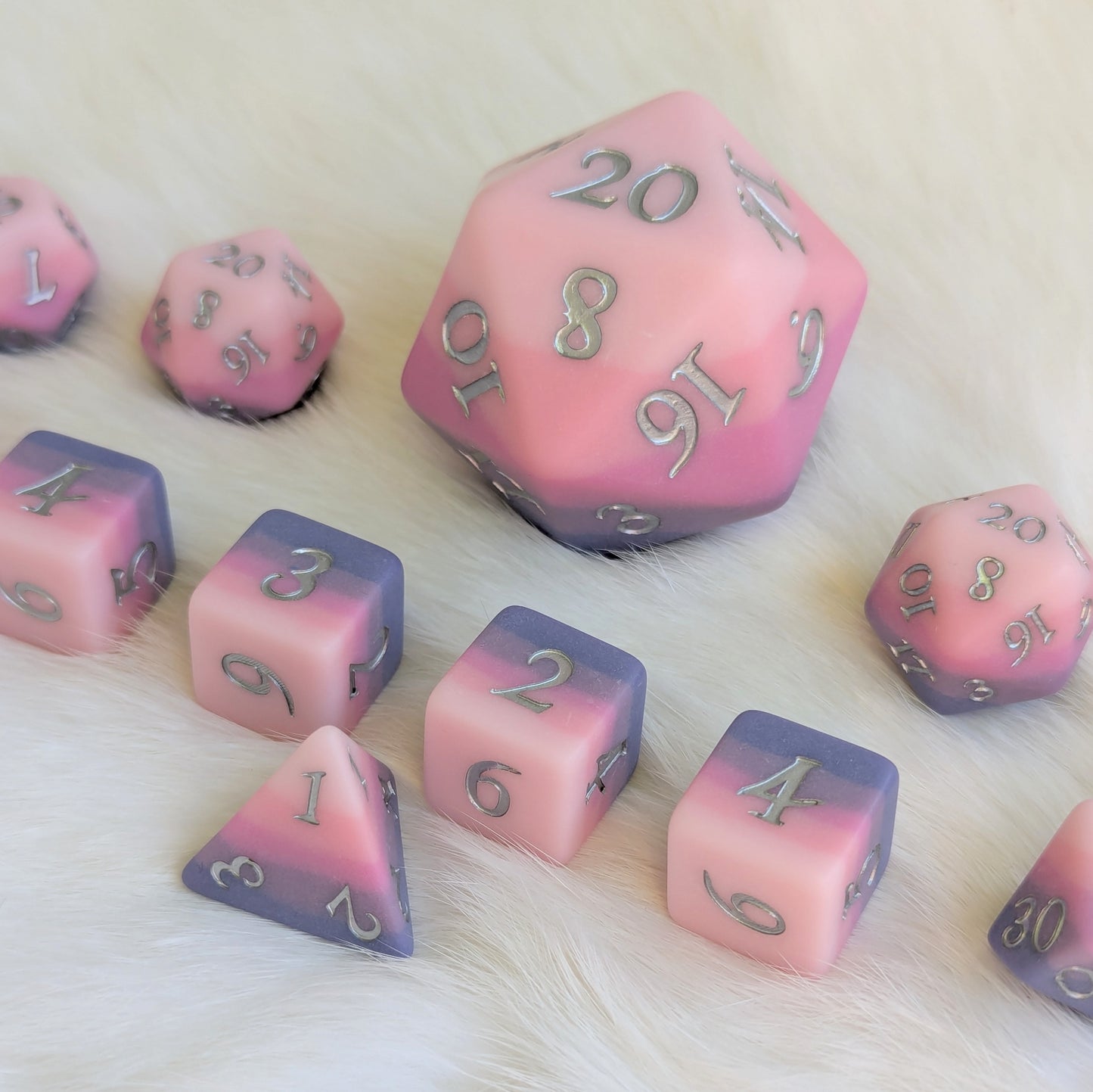 Dreamweaver oversized D20 die set featuring soft pink and lavender ombre design with silver numbers on a white background.