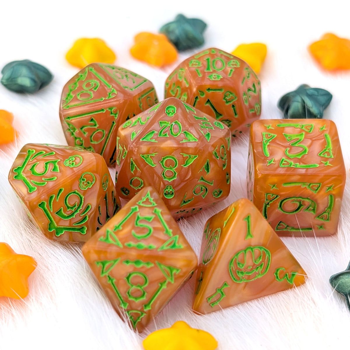 Pumpkin Parade Halloween acrylic DnD dice in pearly marbled pumpkin orange with bright green numbers and illustrations of ghosts, bats, broomsticks, skulls, bones, and jack-o'-lanterns