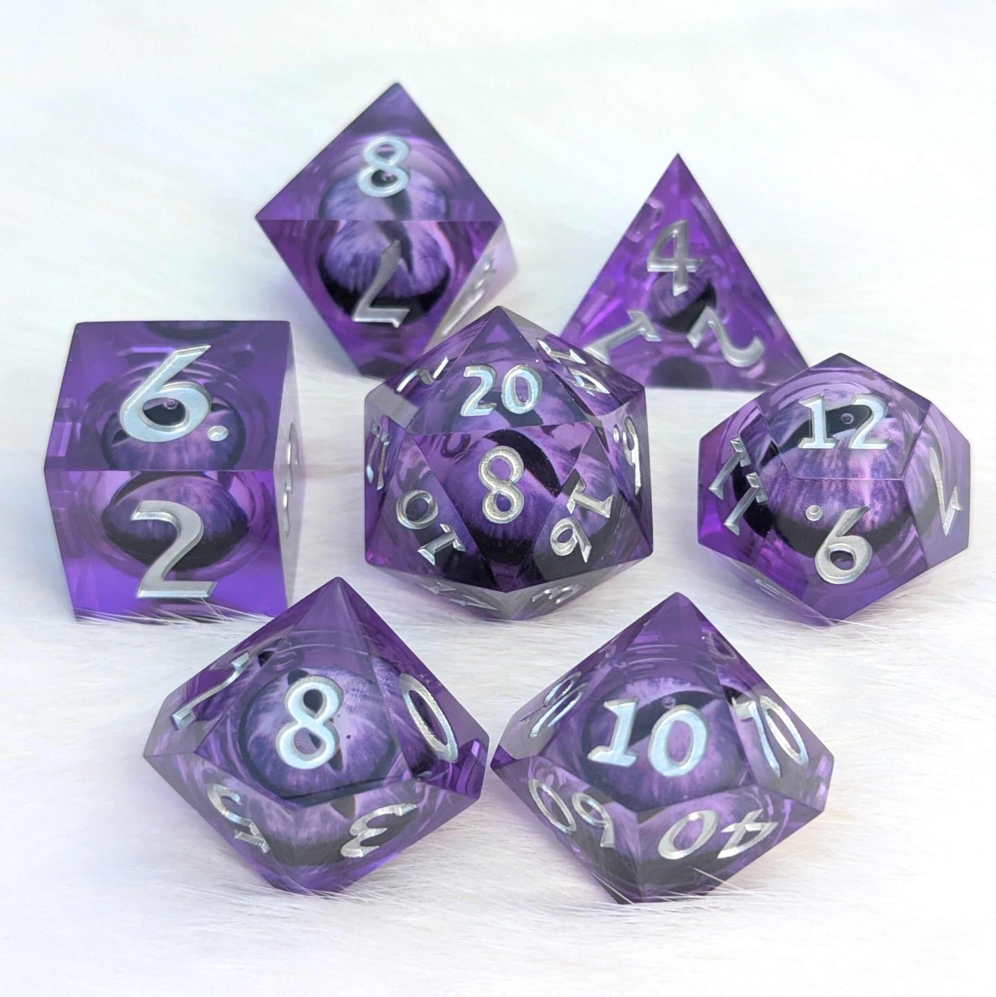 Amethyst Edition All-Seeing Eye Dice Set with liquid core and purple eye design, 7-piece polyhedral set on white background.