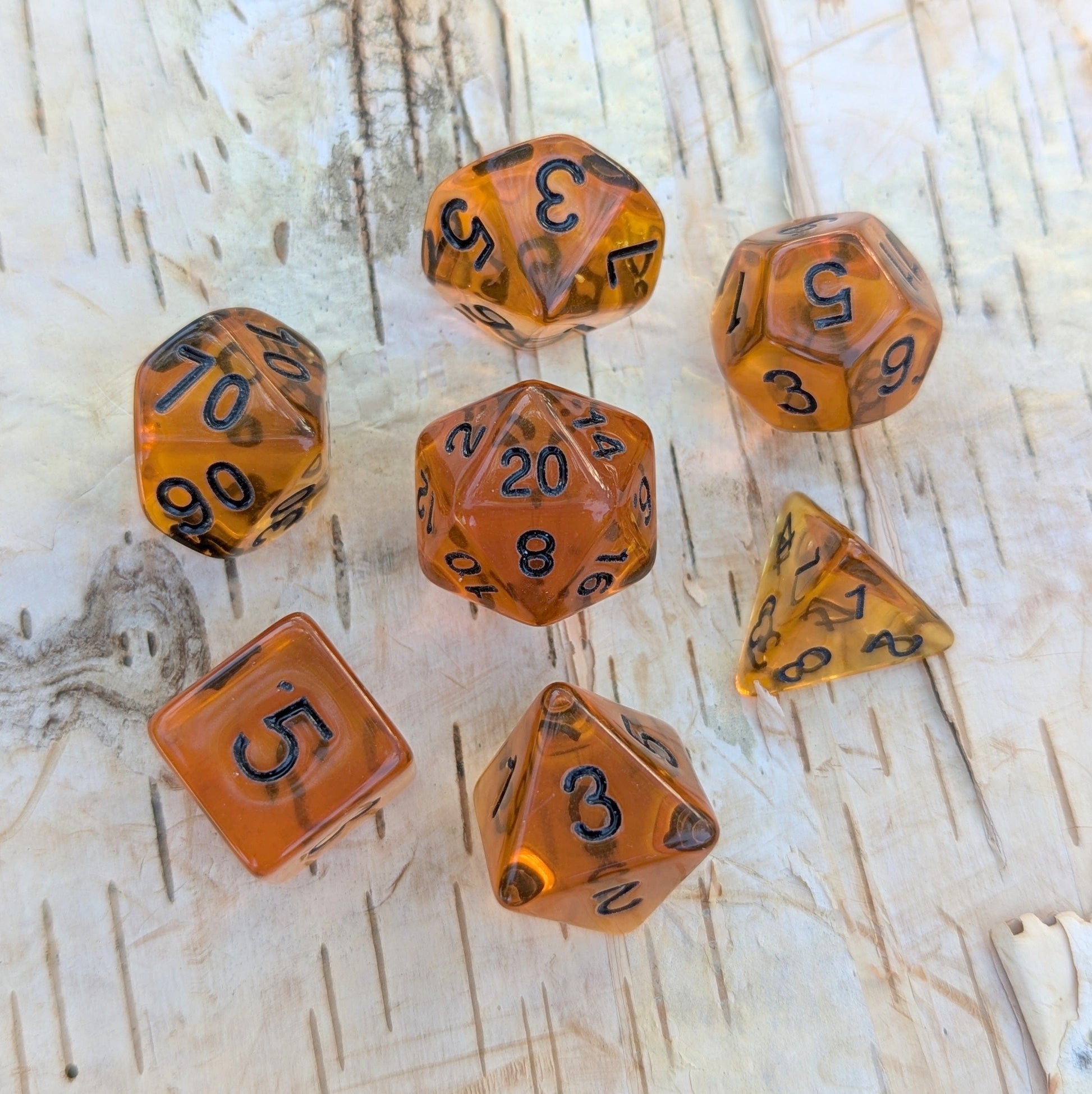 Amber Gems Dice Set with clear auburn-brown hue and black numbers for tabletop RPGs like Dungeons & Dragons.