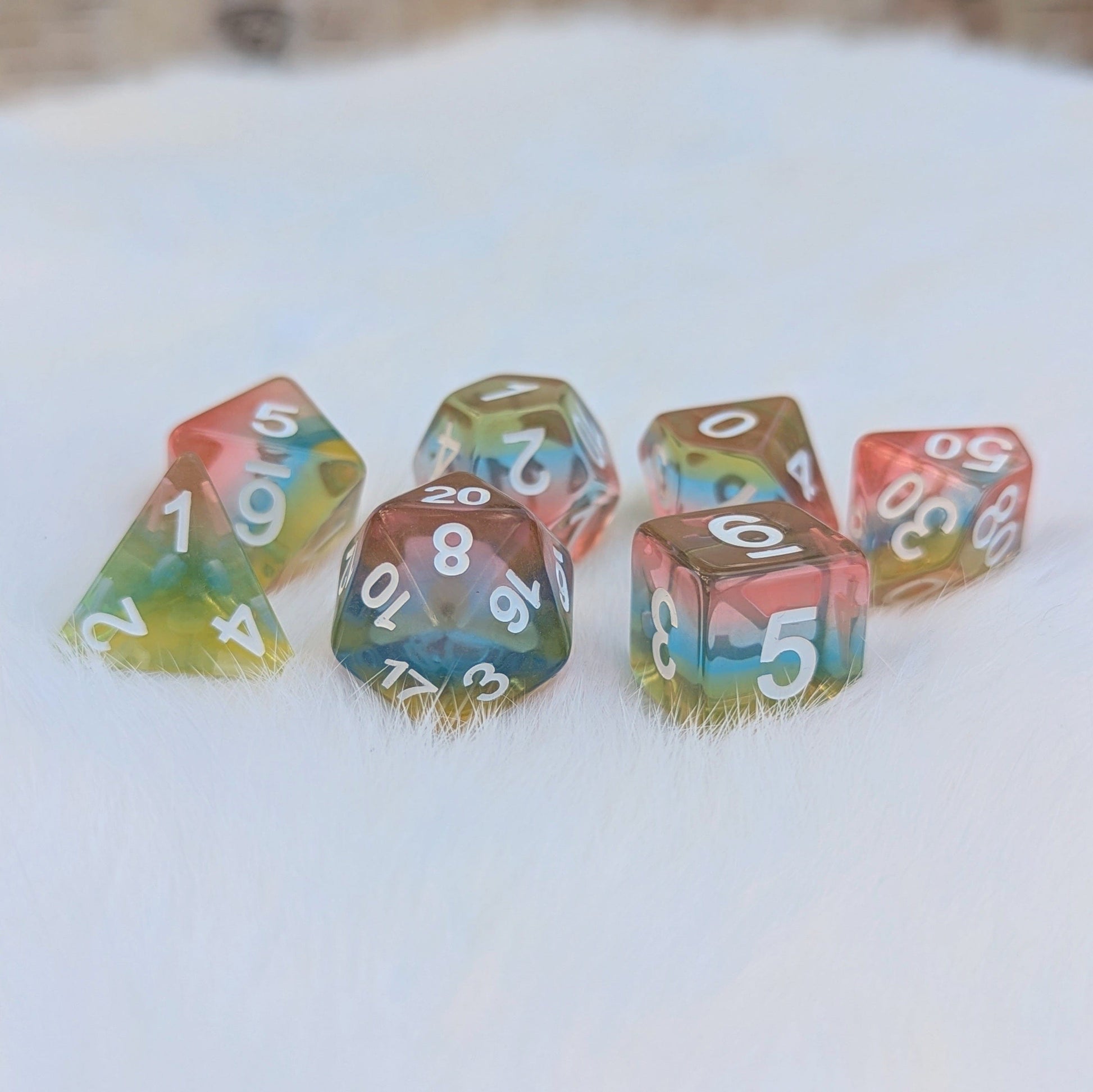 Aurora Sky Dice Set features rainbow layered resin dice with clear light pink, blue, and yellow hues, ideal for tabletop RPGs.