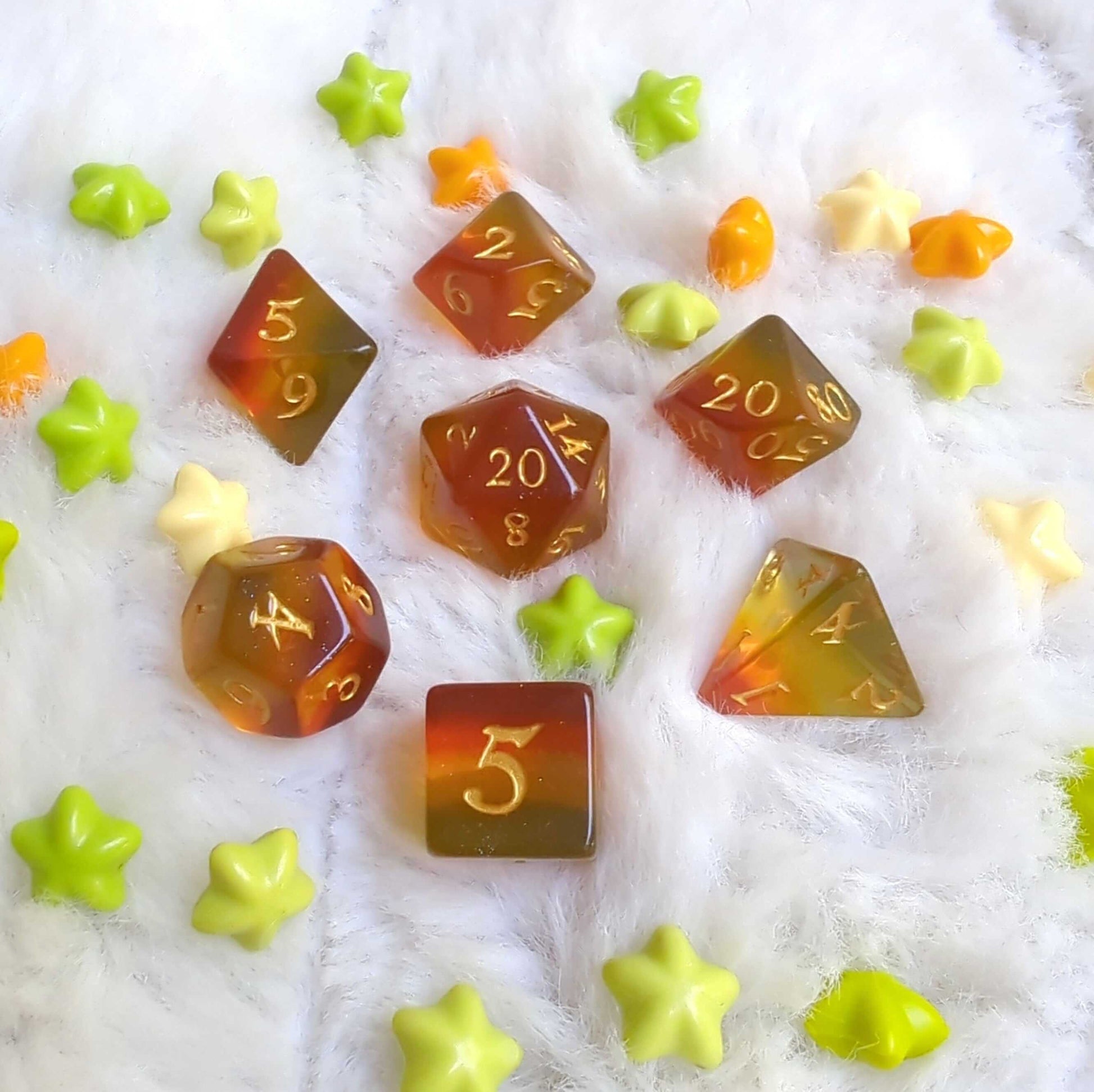 Autumn Sparkles Dice Set with fall-colored layers and glitter, displayed on a soft surface surrounded by star-shaped decorations.