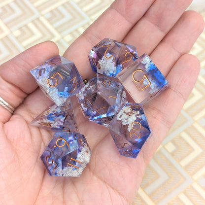 Hand holding Clouds Sharp Edge DnD Dice Set featuring blue and purple resin with cloud inclusions for tabletop gaming.