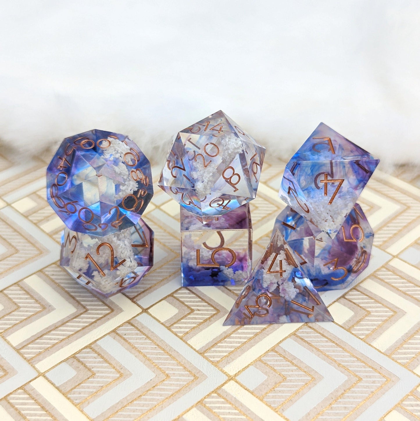 Sharp-edged resin dice set with blue and purple tints, featuring white cloud inclusions, perfect for Dungeons & Dragons.