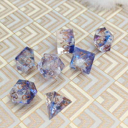 "Clouds Sharp Edge DnD Dice Set with blue and purple resin and cloud inclusions on patterned surface"