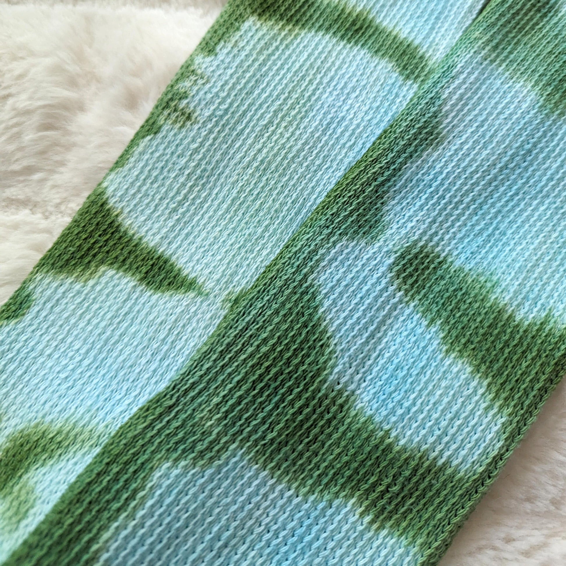 Tie-dyed blue and green cotton fabric close-up of Cozy Sea Elf Socks, showcasing the medium weave and pattern.