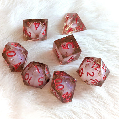 Crimson liquid core sharp edge resin DnD dice set with red numbers on a white fur background; ideal for tabletop role-playing games.