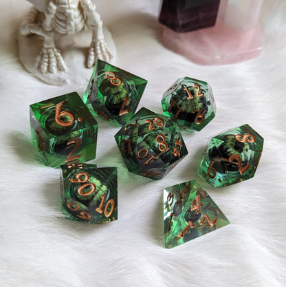 Dark green DnD dice set with moving eye liquid core and sharp edge design on white fur background.