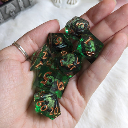 Dark green liquid core DnD dice set with moving eyes in a hand, sharp edge resin polyhedral dice for tabletop RPGs.