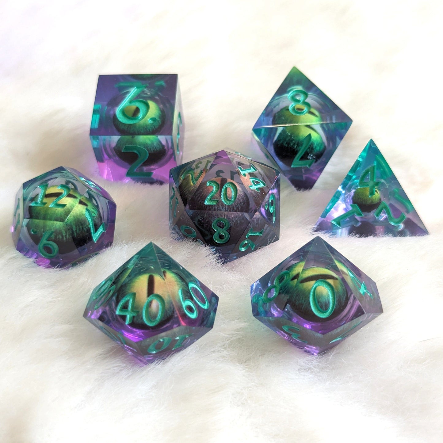 Draconic Moving Eye Liquid Core Sharp Edge Resin DnD Dice Set with 7 polyhedral pieces on a soft white background.