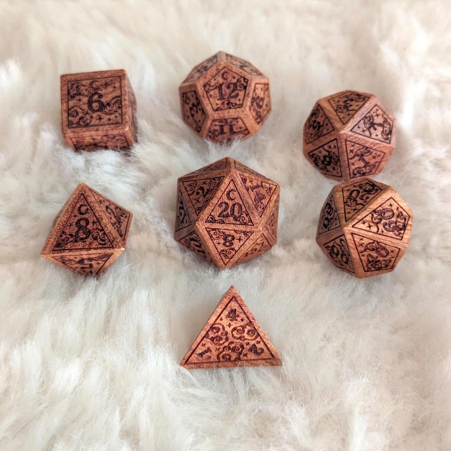 Dreamy Star and Moon Wood Dice Set for Dungeons & Dragons with celestial designs on a soft surface.