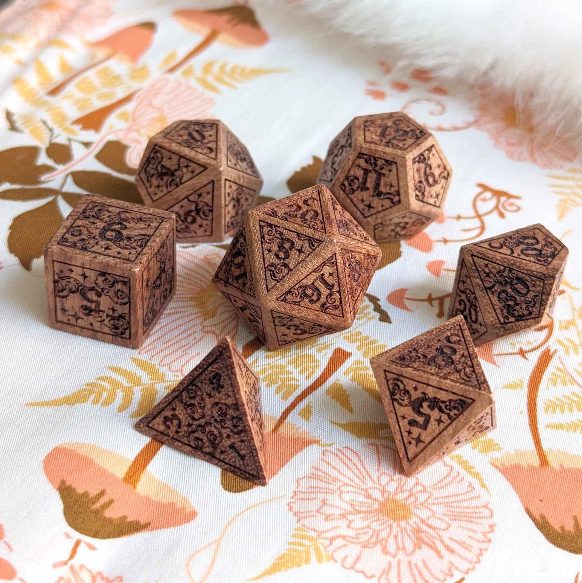 Dreamy Star and Moon Wood Dice Set with intricate design on floral cloth background for DnD gaming adventures.