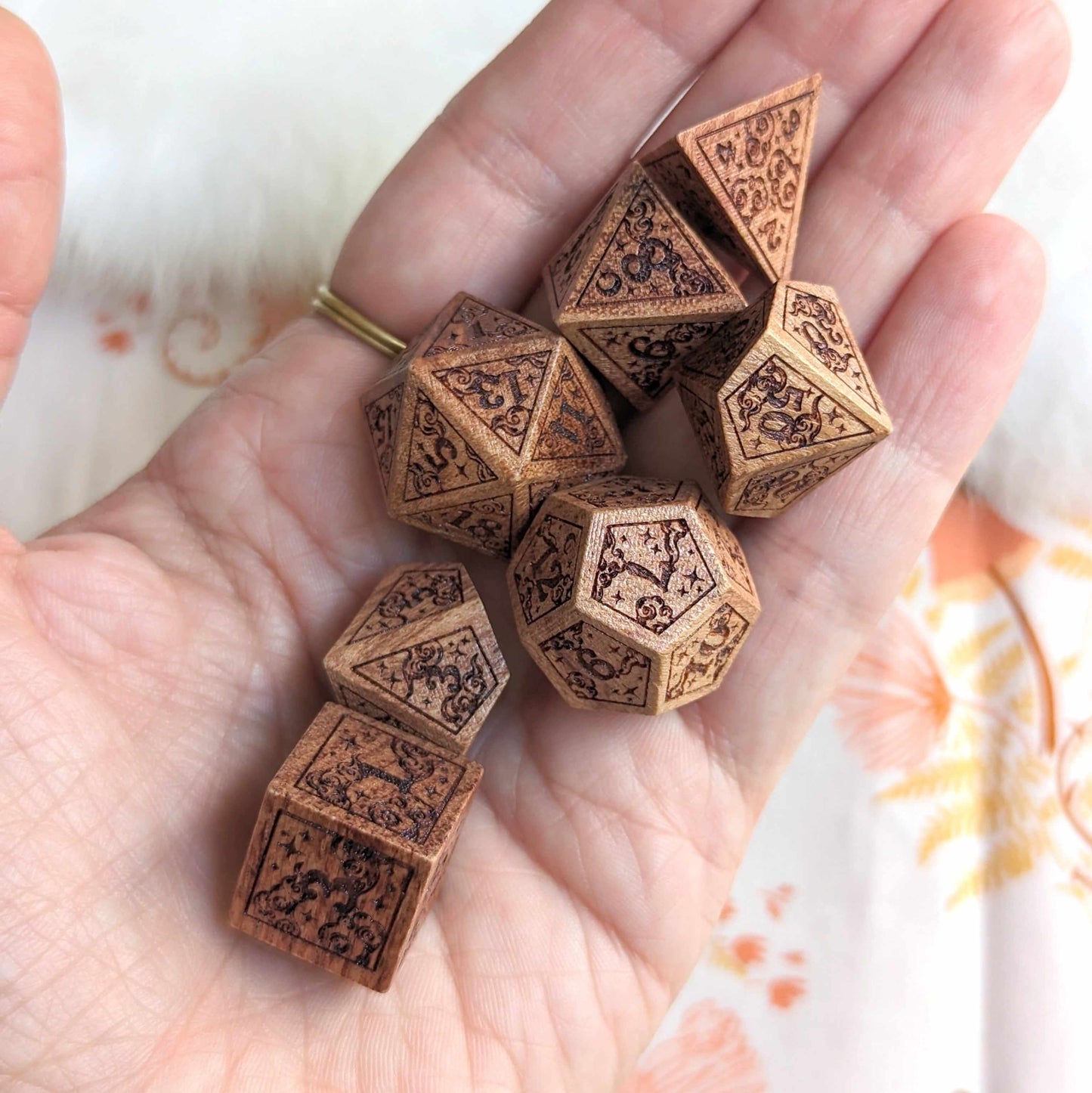 Hand holding Dreamy Star and Moon Wood Dice Set with intricate celestial designs for Dungeons & Dragons gaming.