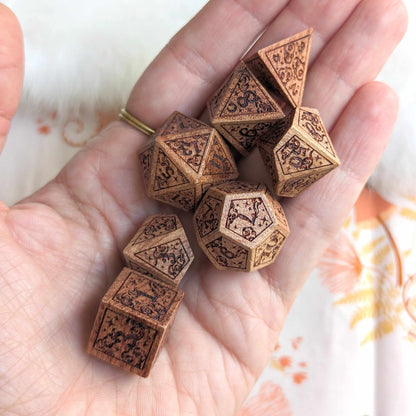 Hand holding Dreamy Star and Moon Wood Dice Set with intricate celestial designs for Dungeons & Dragons gaming.