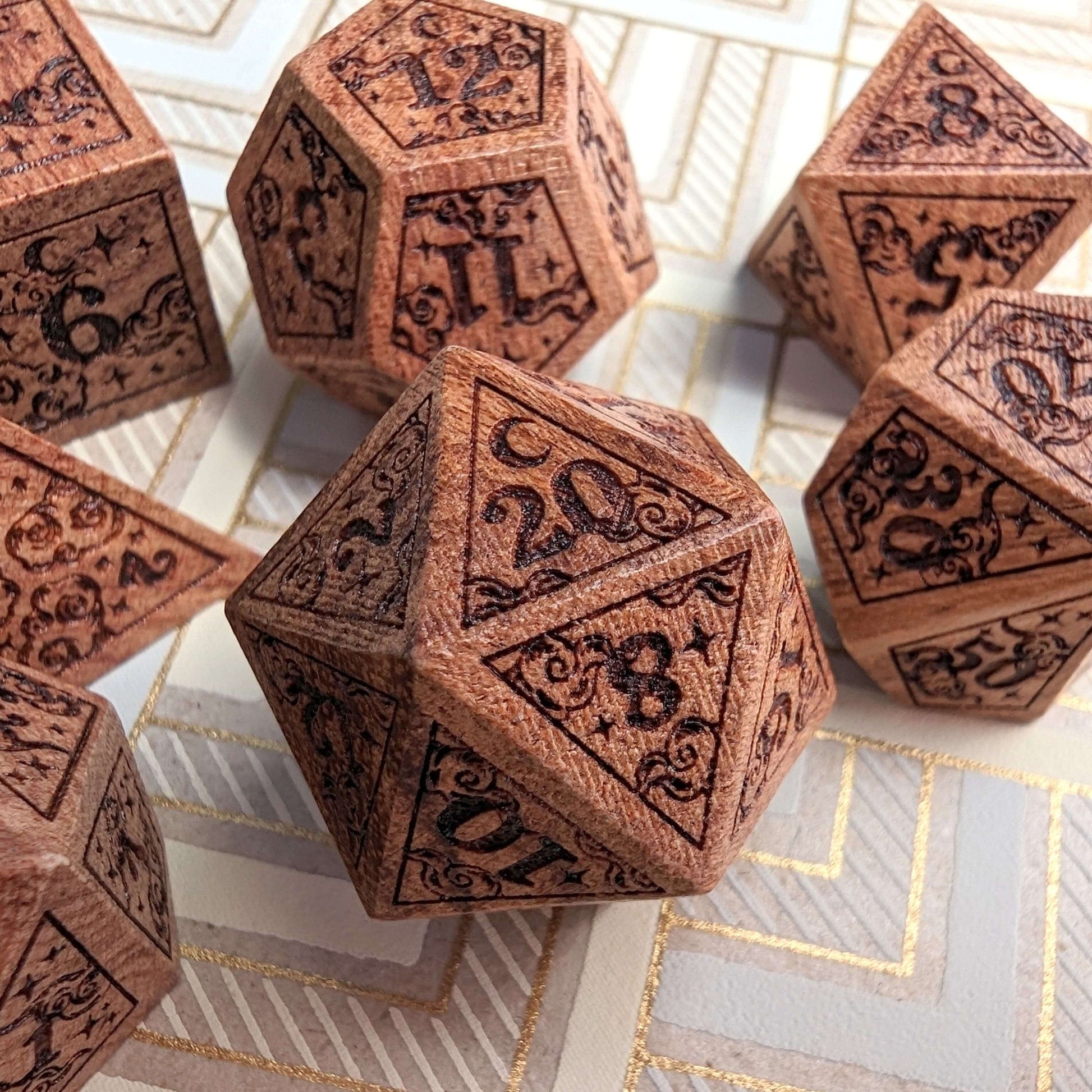 Dreamy Star and Moon wood dice set with intricate celestial designs, featuring a D20 and other essential DnD dice displayed on a patterned surface.